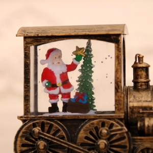 Detailed close-up of a bronze Christmas train water globe with Santa and a tree
