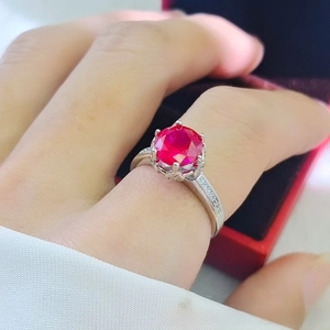 Macro detail of luxury 2-carat red ruby ring with six-prong setting and side diamonds