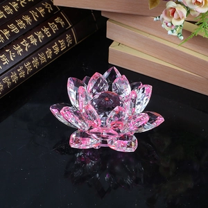 Pink crystal lotus flower ornament with multi-faceted petals on reflective surface