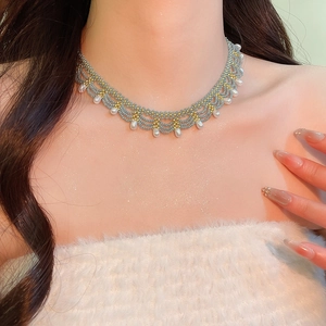 Detail of beaded choker necklace with grey-blue beads and white teardrop pearls