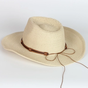 Detailed weave pattern of a beige summer straw cowboy hat with a brown leather decorative band