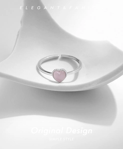 Macro shot of silver adjustable ring with pink heart opal stone and beaded bezel detail