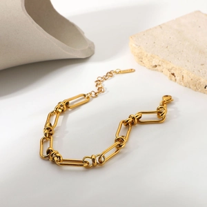 Detail shot of a 18K gold plated stainless steel chunky chain bracelet on textured stone