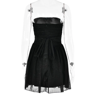 Detail of black strapless mini dress with glitter finish and a bow on the back