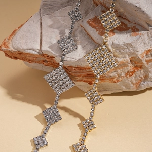 Elegant long fringe geometric diamond earrings set in gold and silver with sparkling crystals