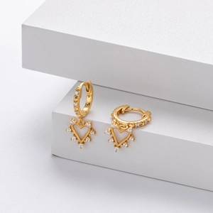 Macro shot of gold S925 silver heart earrings with sparkling cubic zirconia pavé