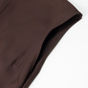 Close-up of pocket stitching on a brown sleeveless dress with high-quality twill texture