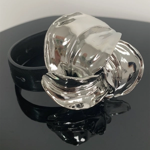 Detailopname van een brede zwarte lederen armband met een grote zilveren bloemengesp