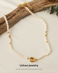 Close-up of irregular freshwater pearls with gold bead accents and double ring centerpiece