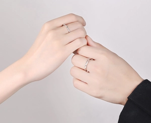 Nahaufnahme von Mobius-Partnerringen mit silbernem Twist-Design und Diamant-Akzenten