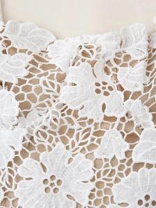 Gros plan sur le tissu en dentelle florale blanche avec broderies délicates de la robe