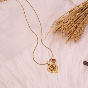 Collier élégant doré avec pendentif cœur gravé de roses et une petite pierre précieuse rouge