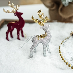 Close-up of silver and wine red glitter reindeer ornaments in a snowy festive scene