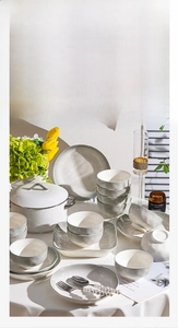French style matte ceramic dinnerware set with bowls and pots in a cozy dining setting