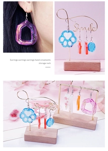 Detail of assorted resin earrings with glitter and dried flowers on a Smile jewelry rack