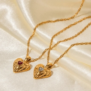 Elegant gold heart necklaces with red and white zircon crystals on silk fabric