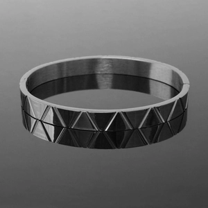 Detailed close-up of dark grey gunmetal bangle with geometric triangular textures