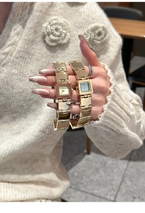 Gros plan de montres carrées dorées avec bracelets en métal poli et cadrans élégants