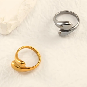 Detail of open gold and black titanium steel rings with overlapping teardrop design