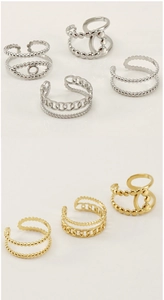 Detail of adjustable 18K gold and silver layered rings with beaded and Cuban chain design