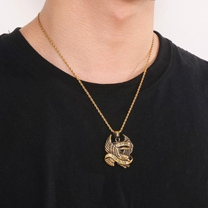 Detailed close-up of a golden eagle pendant with Live To Ride engraving on a twist chain