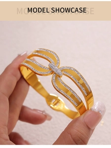 Détail d'un bracelet en acier titane plaqué or 18k avec double arc ajouré et cristaux