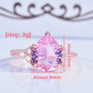 Macro shot of rose gold pear shaped pink gemstone ring with white zircon side stones