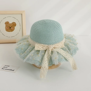 Détail d'un chapeau de paille vert clair pour filles avec nœuds en dentelle et résille