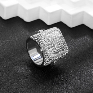 Macro shot of silver hip hop square ring with cubic zirconia on black texture base
