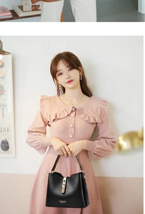 Fashionable black leather handbag with gold hardware styled with a pink ruffle dress