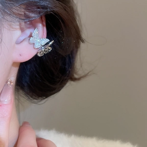 Nahaufnahme einer silbernen Schmetterlings-Ohrklemme mit Zirkonia und Hohl-Design