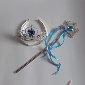 Dettaglio di corona argentata da principessa e bacchetta di fiocco con gemme blu a cuore