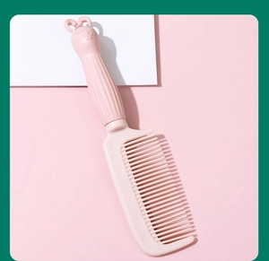 Macro view of a cute pink rabbit-themed fine-tooth plastic hair comb for daily grooming.