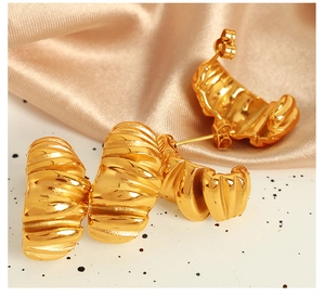 Macro shot of 18K gold plated stainless steel earrings with wavy textured finish