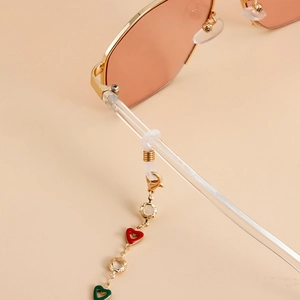 Detail of gold glasses chain with heart charms and crystal rings on gold frame