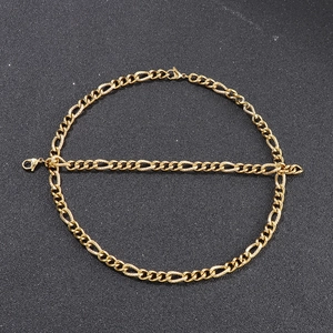Detailed view of golden Figaro chain necklace and bracelet set on black background
