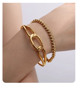 Detail of 18K gold plated bangle set with minimalist interlocking rings and punk stud design