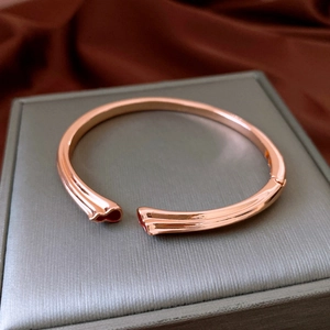 Détail d'un bracelet ouvert or rose avec texture élégante de nœuds de bambou