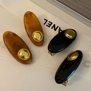 Close-up of elegant tulip-themed resin hair clips with golden studs and metal duckbill clips
