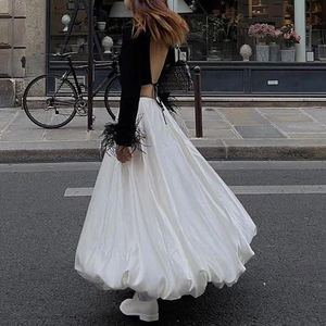 Detail of a chic white satin A-line maxi skirt featuring a voluminous flowing silhouette