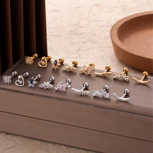 Detailed view of heart and flower cartilage studs with zircon in gold and silver finish
