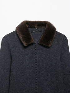 Detail of faux fur collar and knit fabric on dark gray cardigan with fabric buttons
