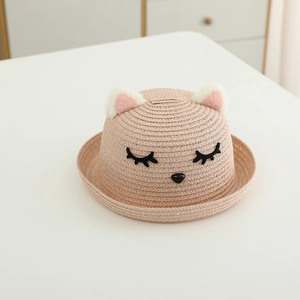 Dettaglio cappello di paglia per bambina con orecchie di gatto in peluche e ricami