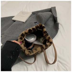 Detailed view of leopard print plush bucket bag showing chain strap and interior items