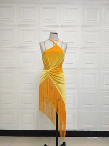 Détail de la robe asymétrique en velours jaune avec de longues franges denses sur le bas