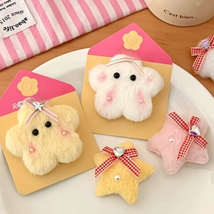 Detailed view of colorful plush star hair clips with pearls and bows on a sweet background