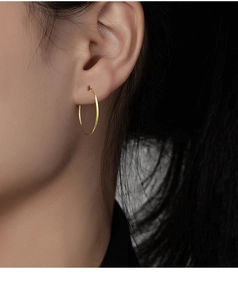 Close-up of minimalist s925 silver hoop earring in gold finish worn by a model