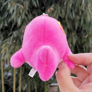 Detail showing the soft fuzzy back texture of this cute pink plush dolphin keychain toy