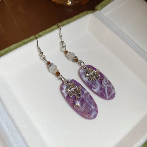 Detail of vintage drop earrings with purple marble resin pendant and silver floral accents