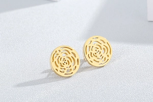 Macro detail of gold-plated hollow rose flower stud earrings with intricate metalwork